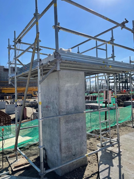 Crane lifting scaffolding materials at a construction site
